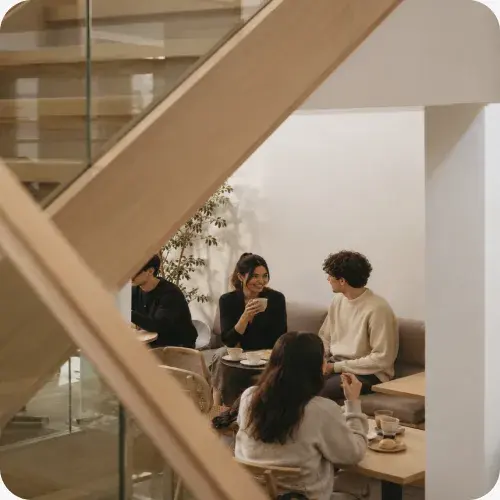 Four people talking over coffee in a café